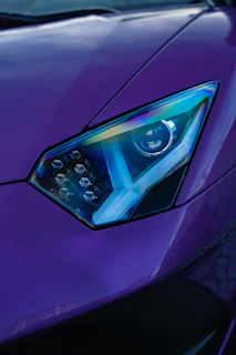 Close-up of a sleek 3D-printed automotive accessory glowing with blue neon light on a dark background.