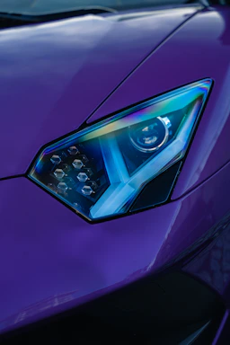Close-up of a sleek 3D-printed automotive accessory glowing with blue neon light on a dark background.
