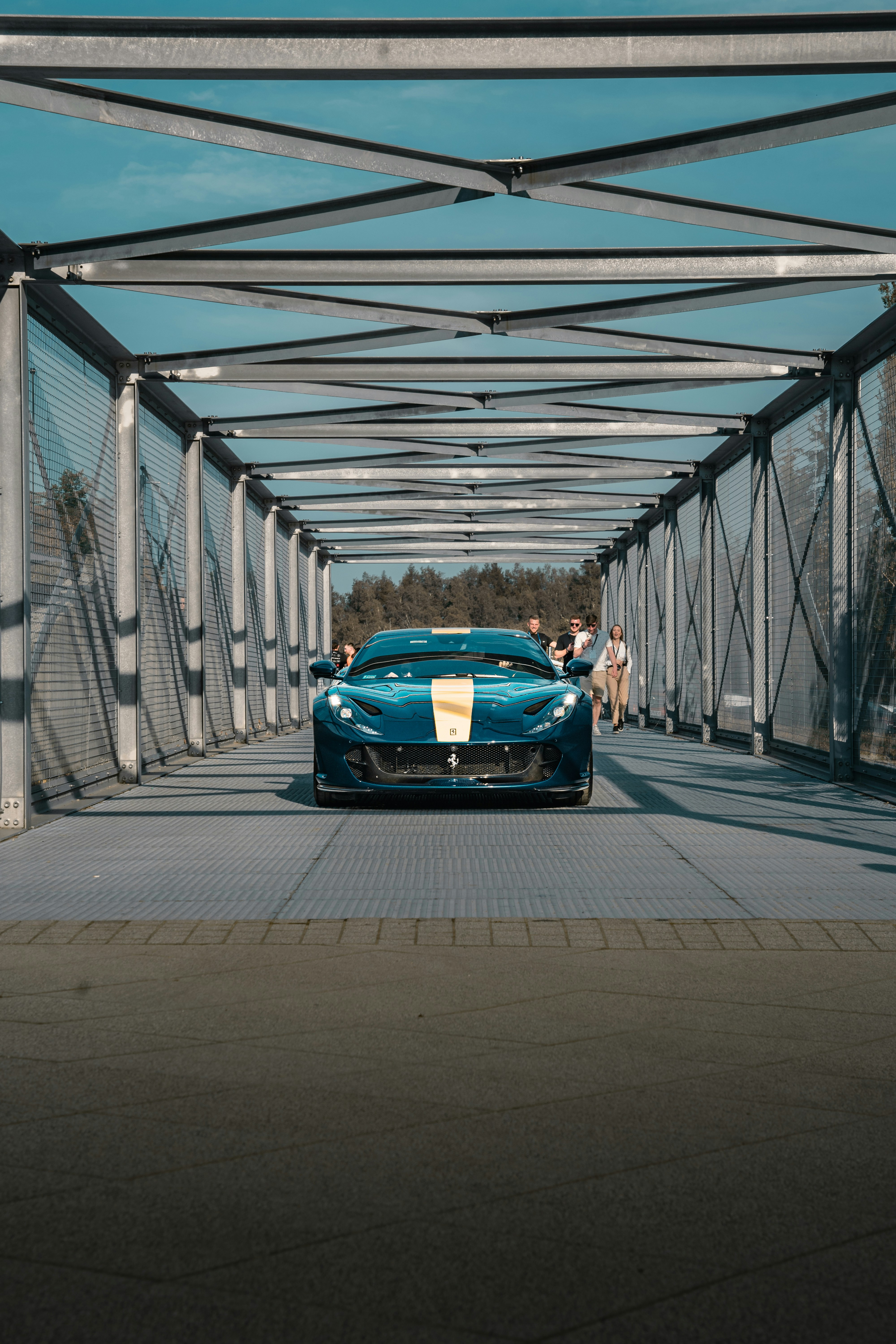 A blue sports car is parked on a bridge photo – Free Grey Image on Unsplash