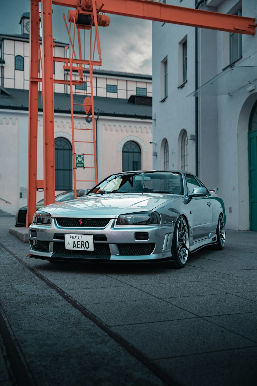 a silver sports car parked in front of a building