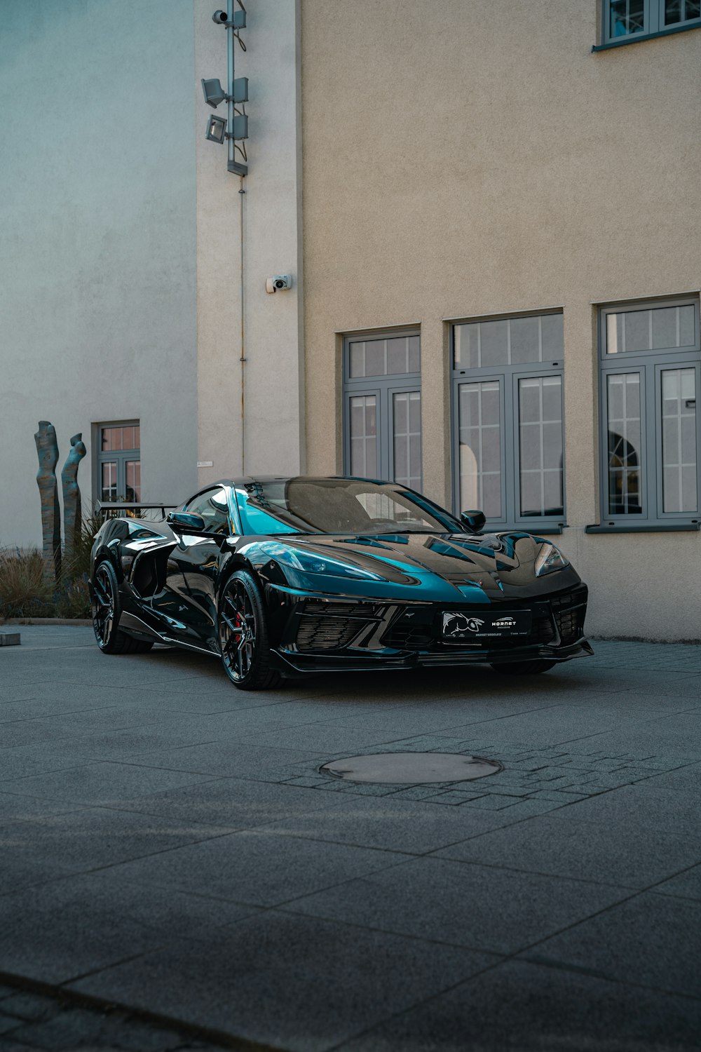 a black and blue sports car parked in front of a building