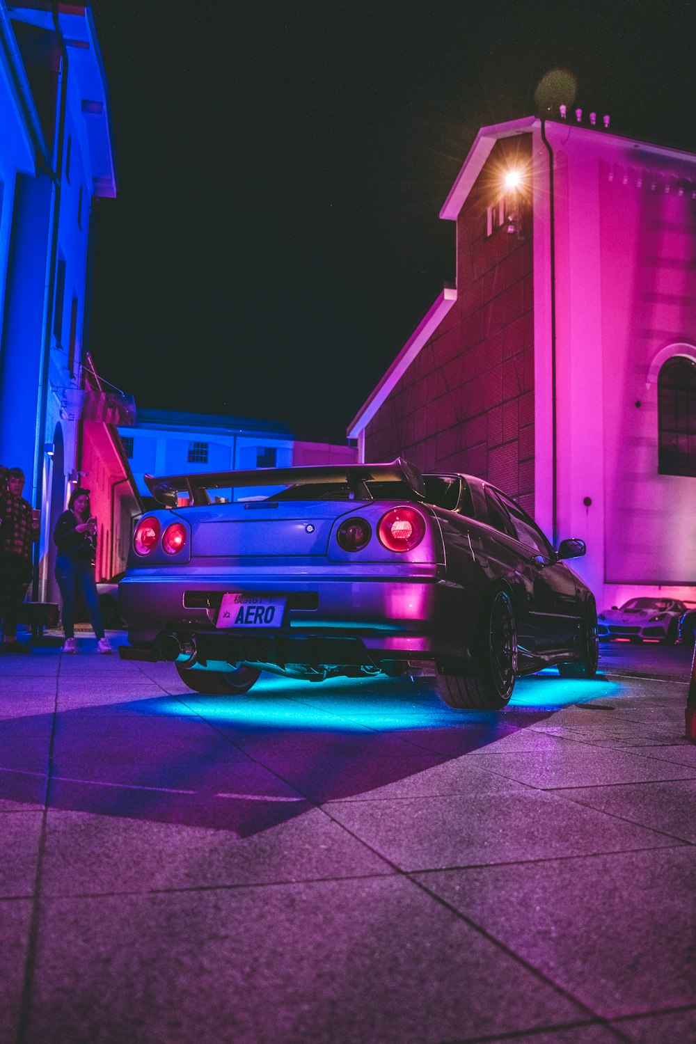 a car parked in front of a building at night