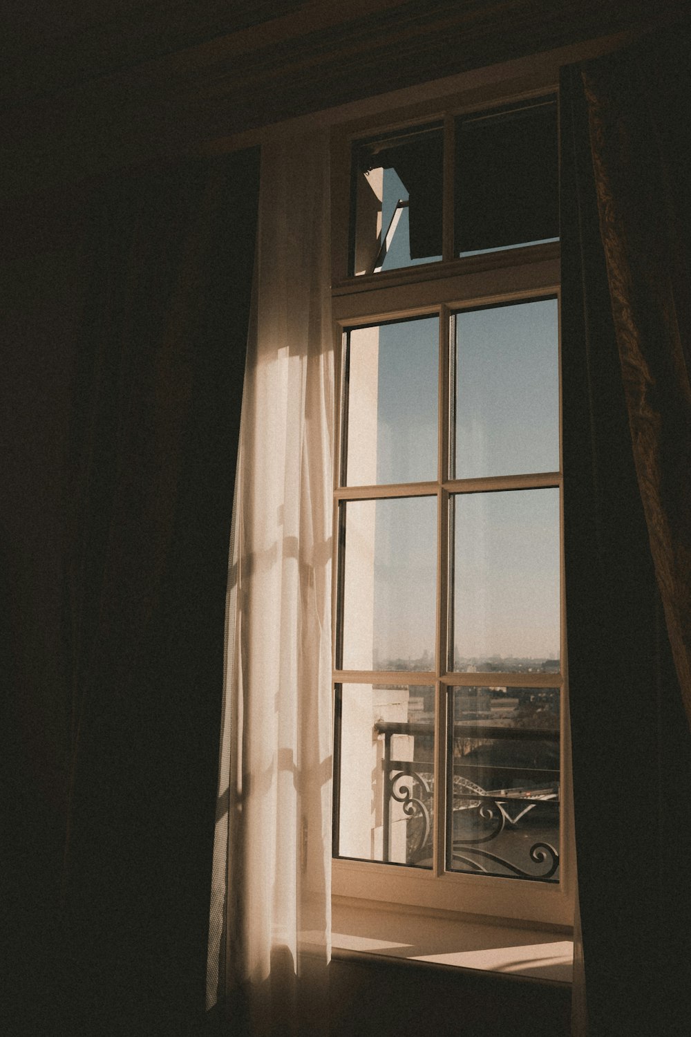 a person looking out of a window at a balcony