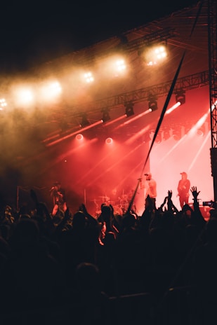 Band performing live on stage with warm lighting and engaged audience.