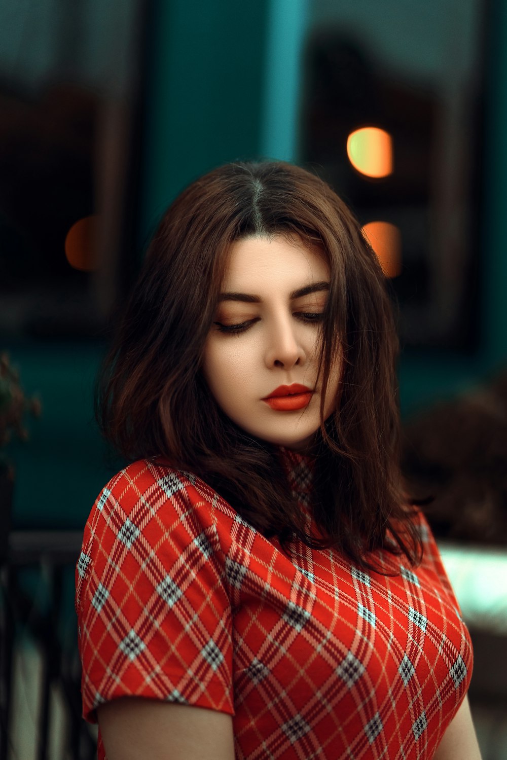 a woman in a red and white dress with her eyes closed