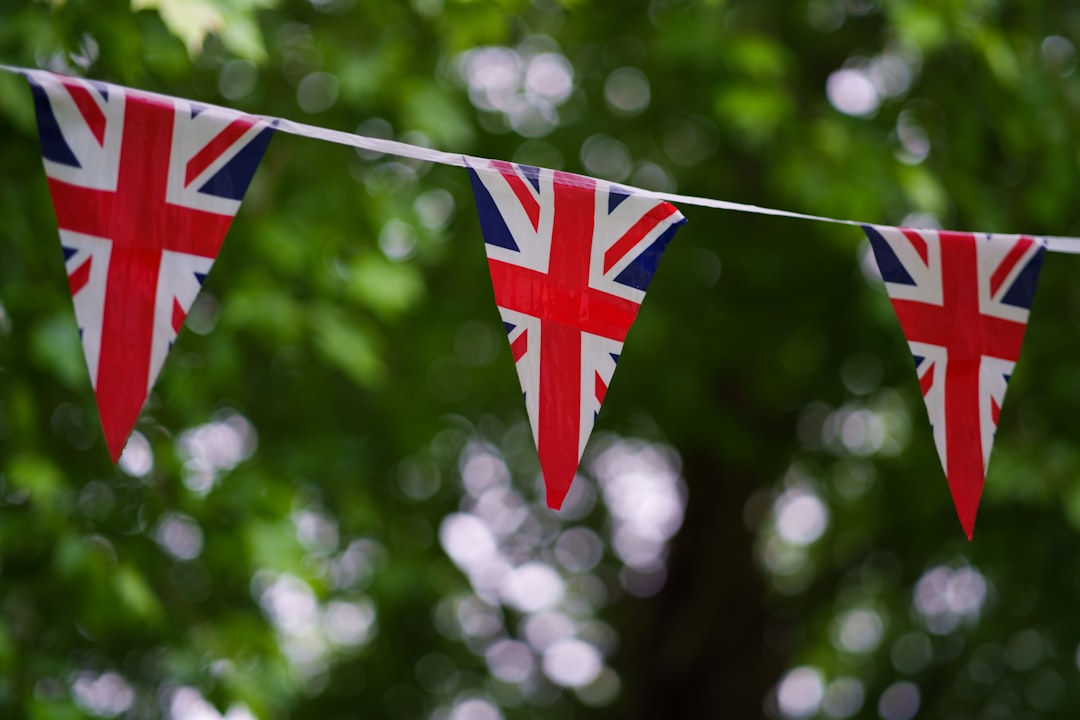 a british flag bunting on a tree line, Union Jack flags out for a celebration such as a coronation or jubilee!