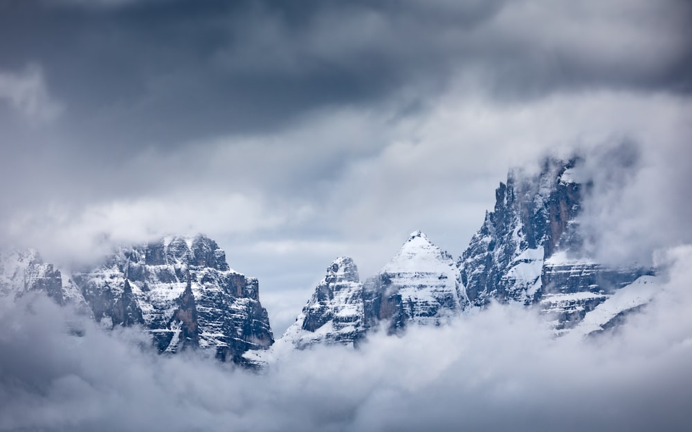 a group of clouds in the sky over a snow covered slope