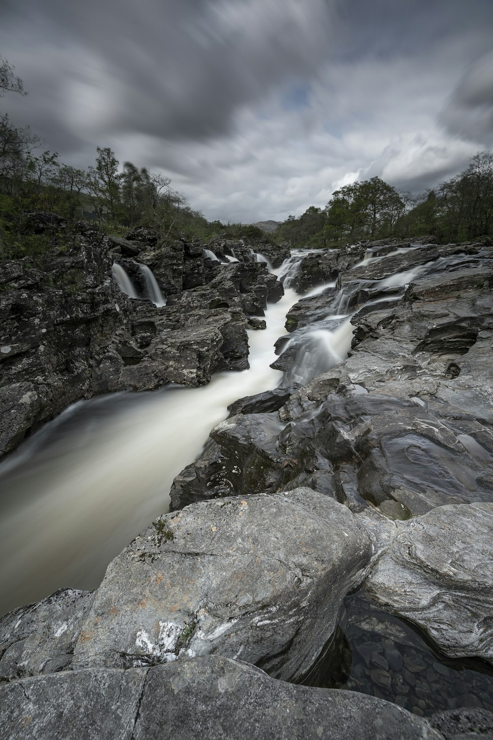 a long exposure photo of a river running between rocks