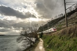 High-speed train running on a scenic railway track at sunrise.