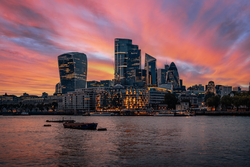 a view of a city at sunset with boats in the water