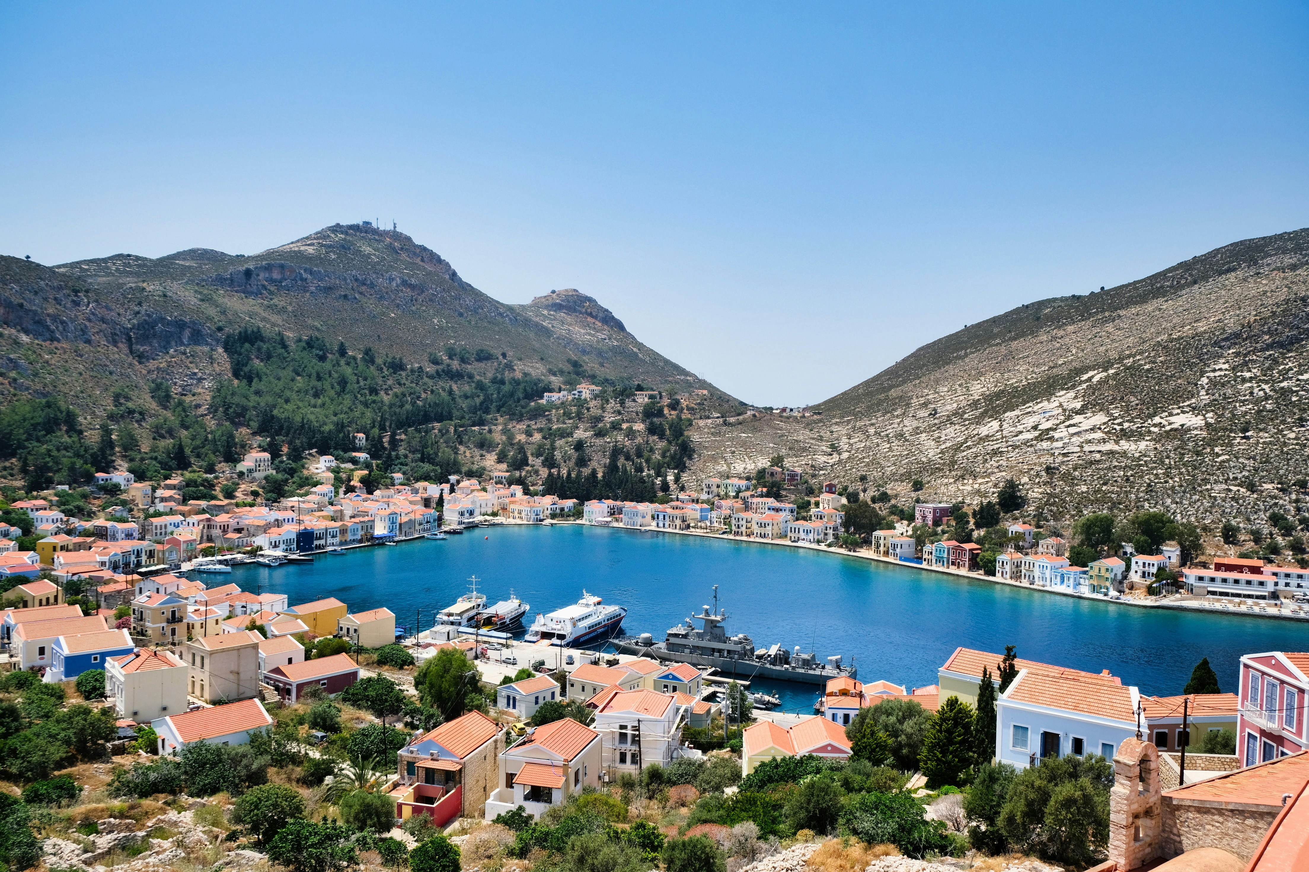 a harbor with a boat in it surrounded by mountains, 