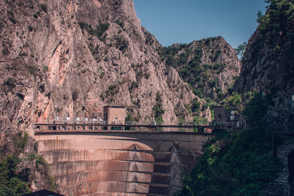 a bridge over a canyon with a mountain in the background