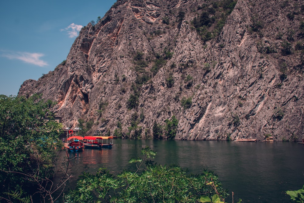 a boat floating on top of a lake next to a mountain