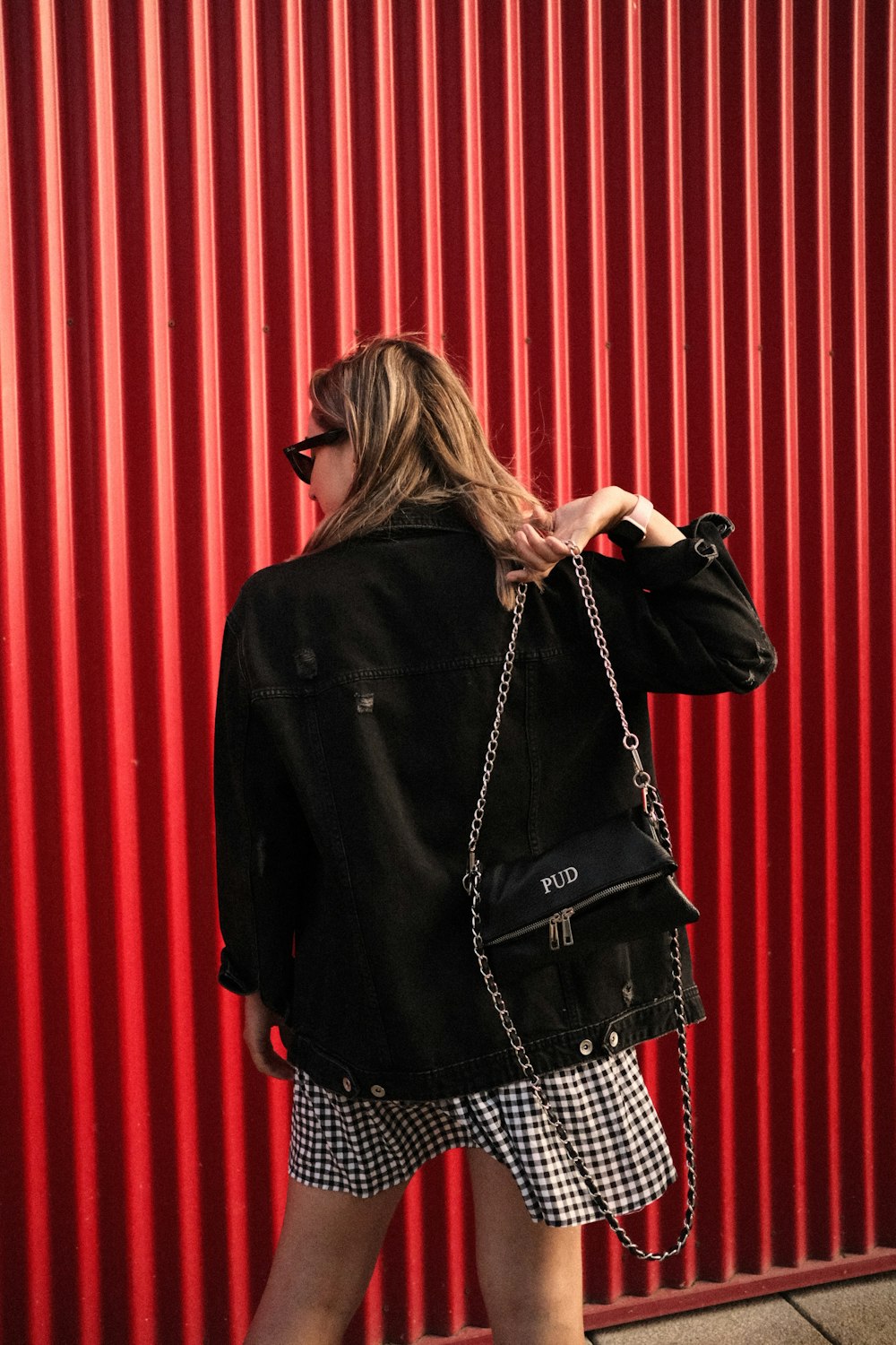 a woman in a black jacket carrying a black purse