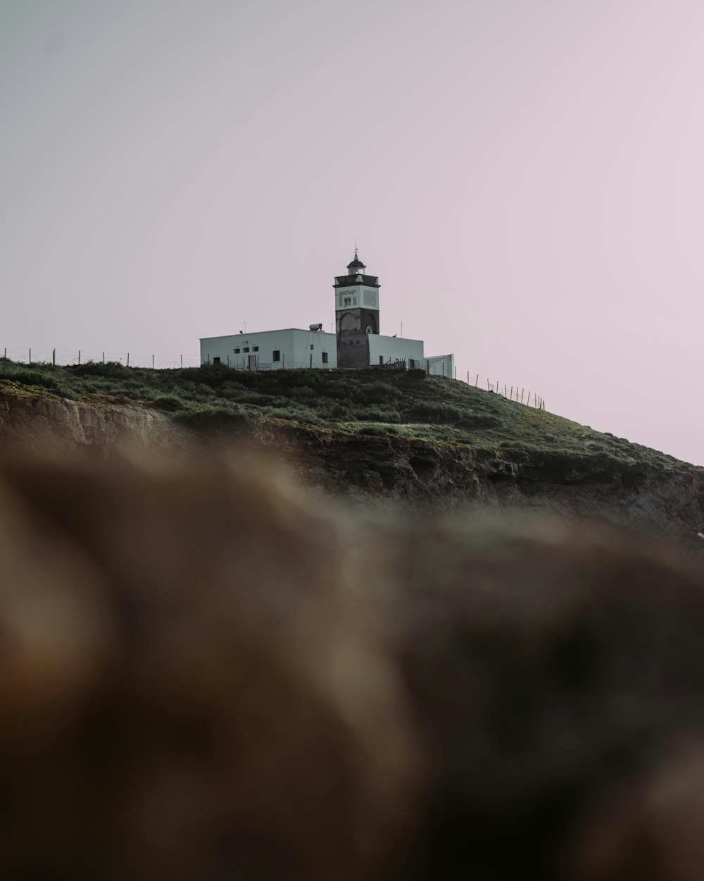 a lighthouse on top of a hill near the ocean