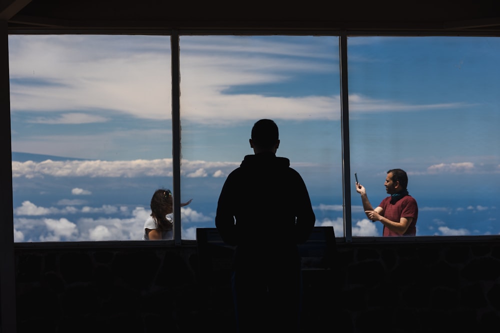 a man standing in front of a window next to a woman