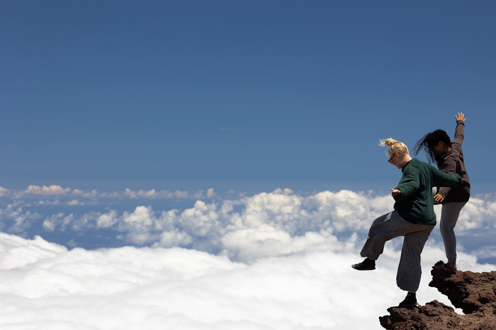 a man and a woman standing on top of a mountain