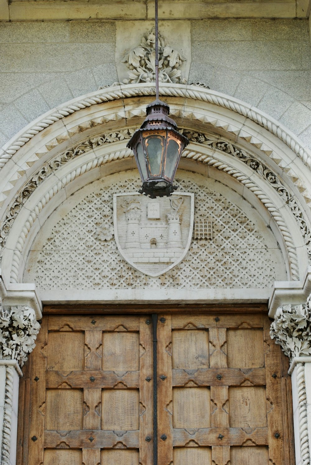 a large wooden door with a light hanging above it