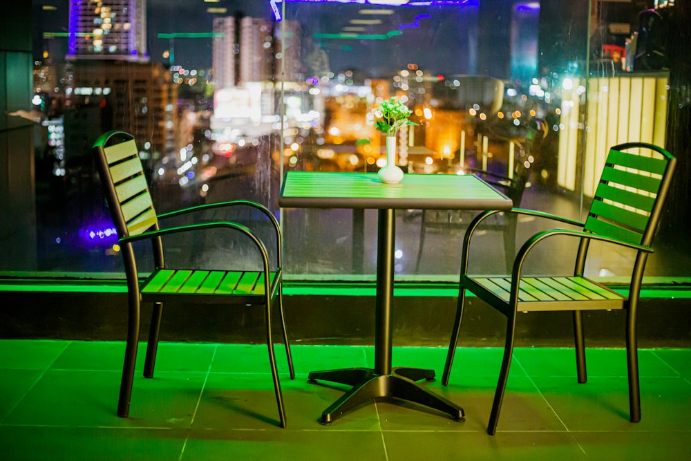 two chairs and a table with a view of a city at night