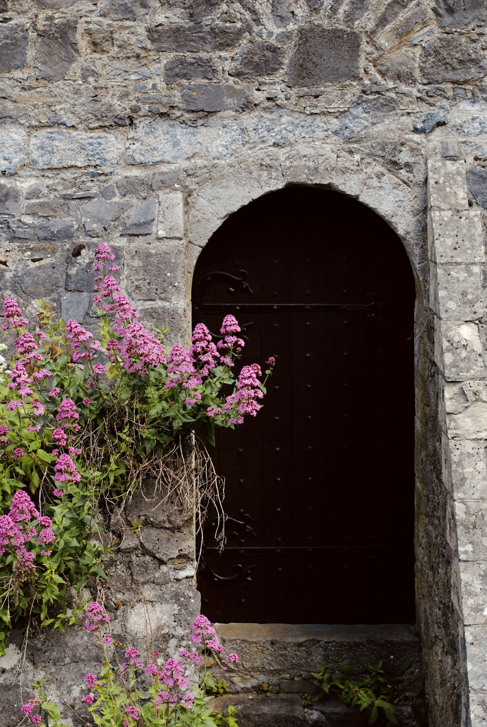 una porta con un mazzo di fiori che ne spuntano