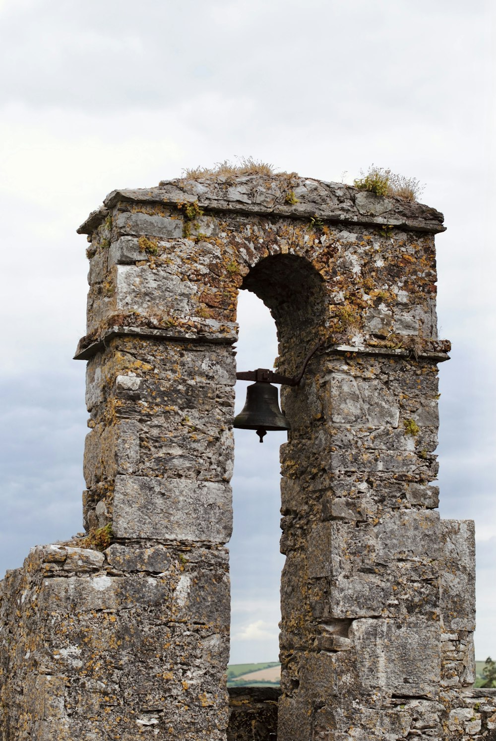 an old stone building with a bell on it