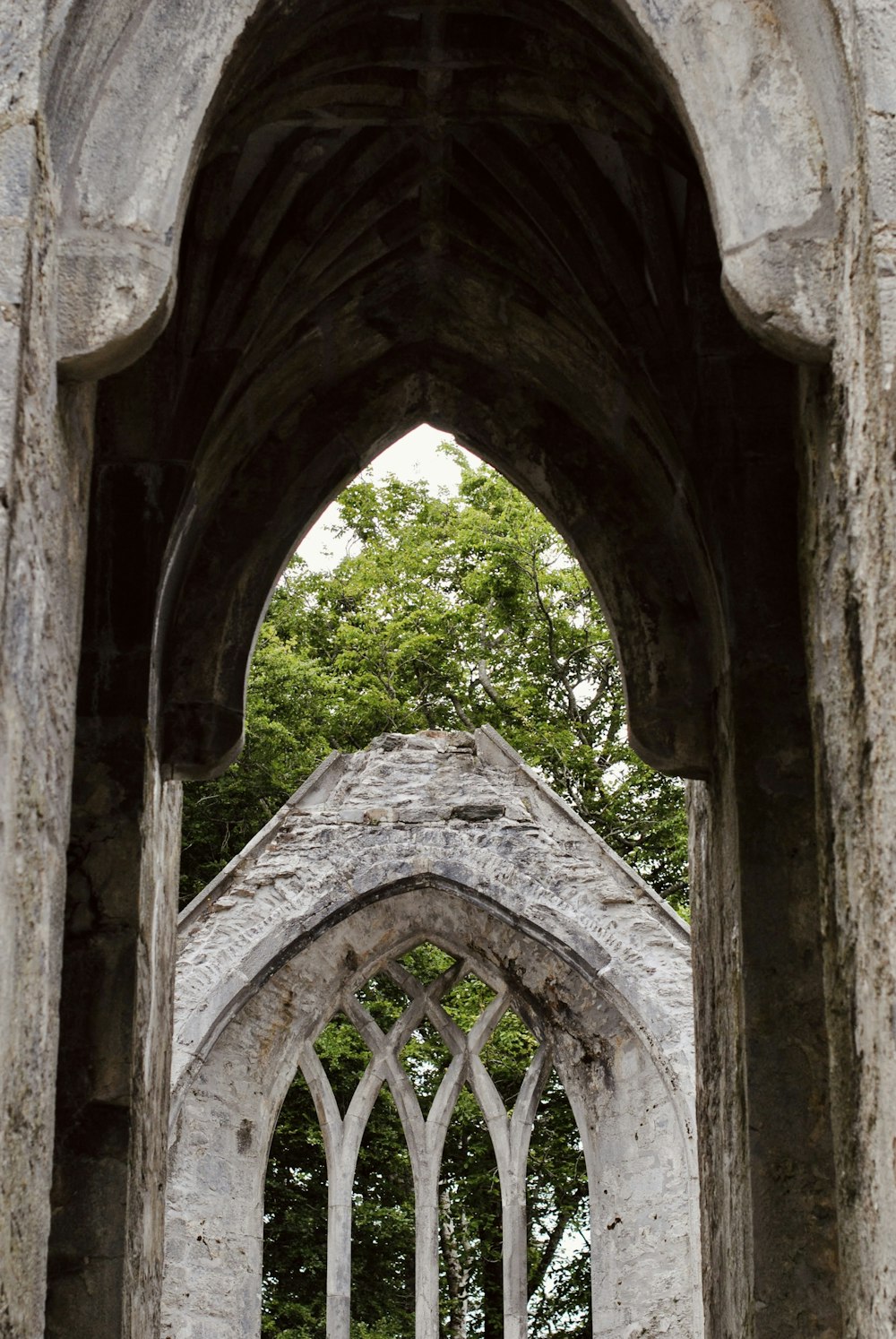 a stone building with a window and a tree in the background