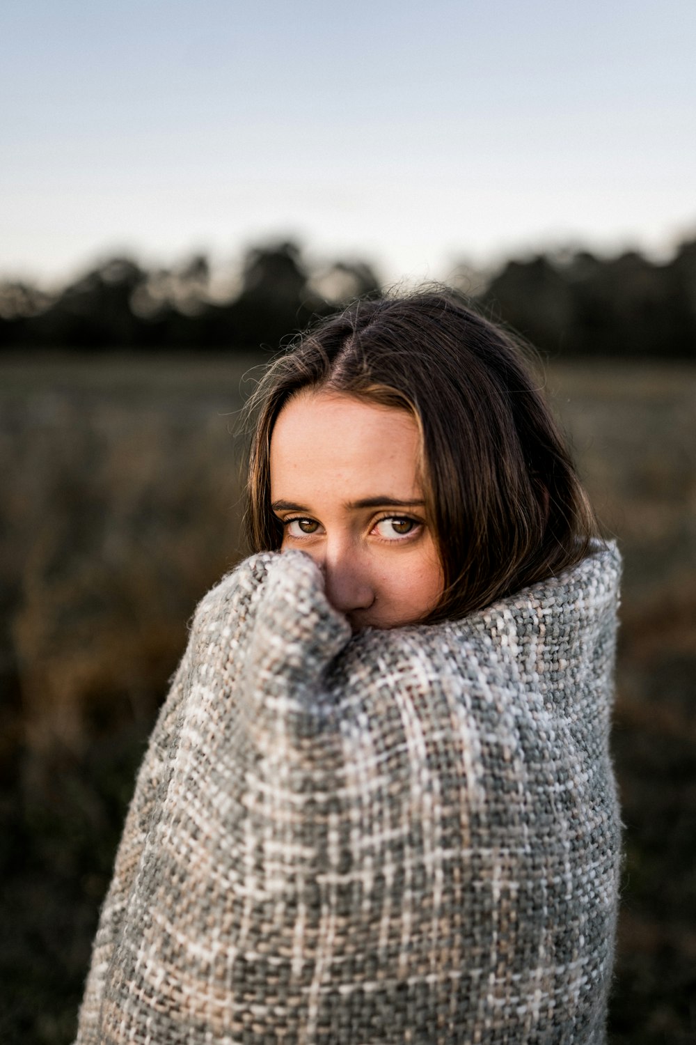 a woman covering her face with a blanket