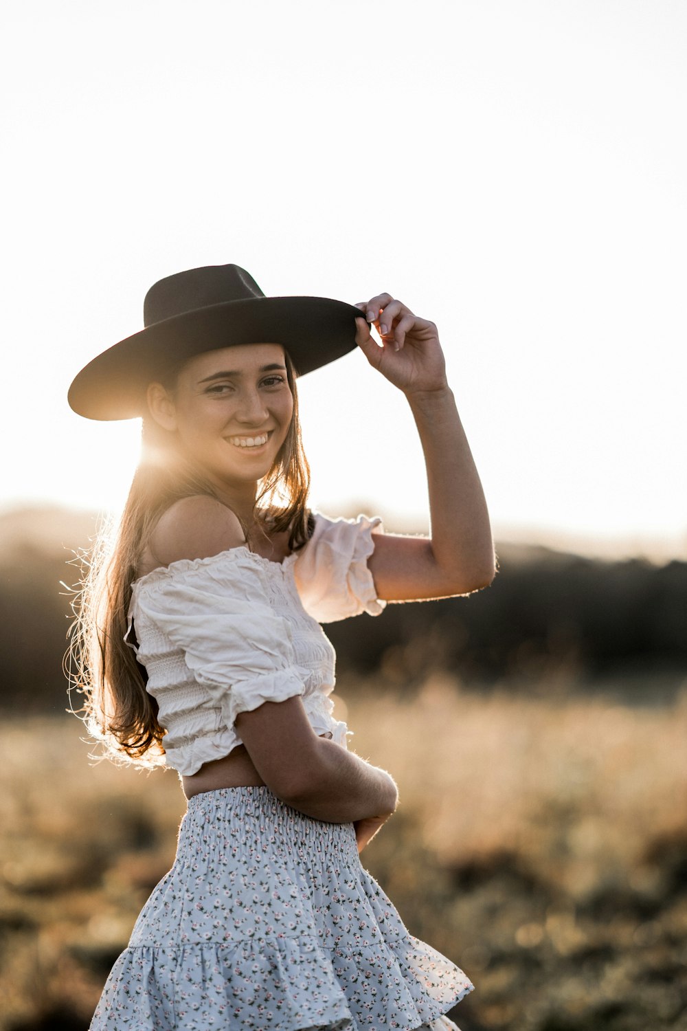 a young girl wearing a cowboy hat in a field