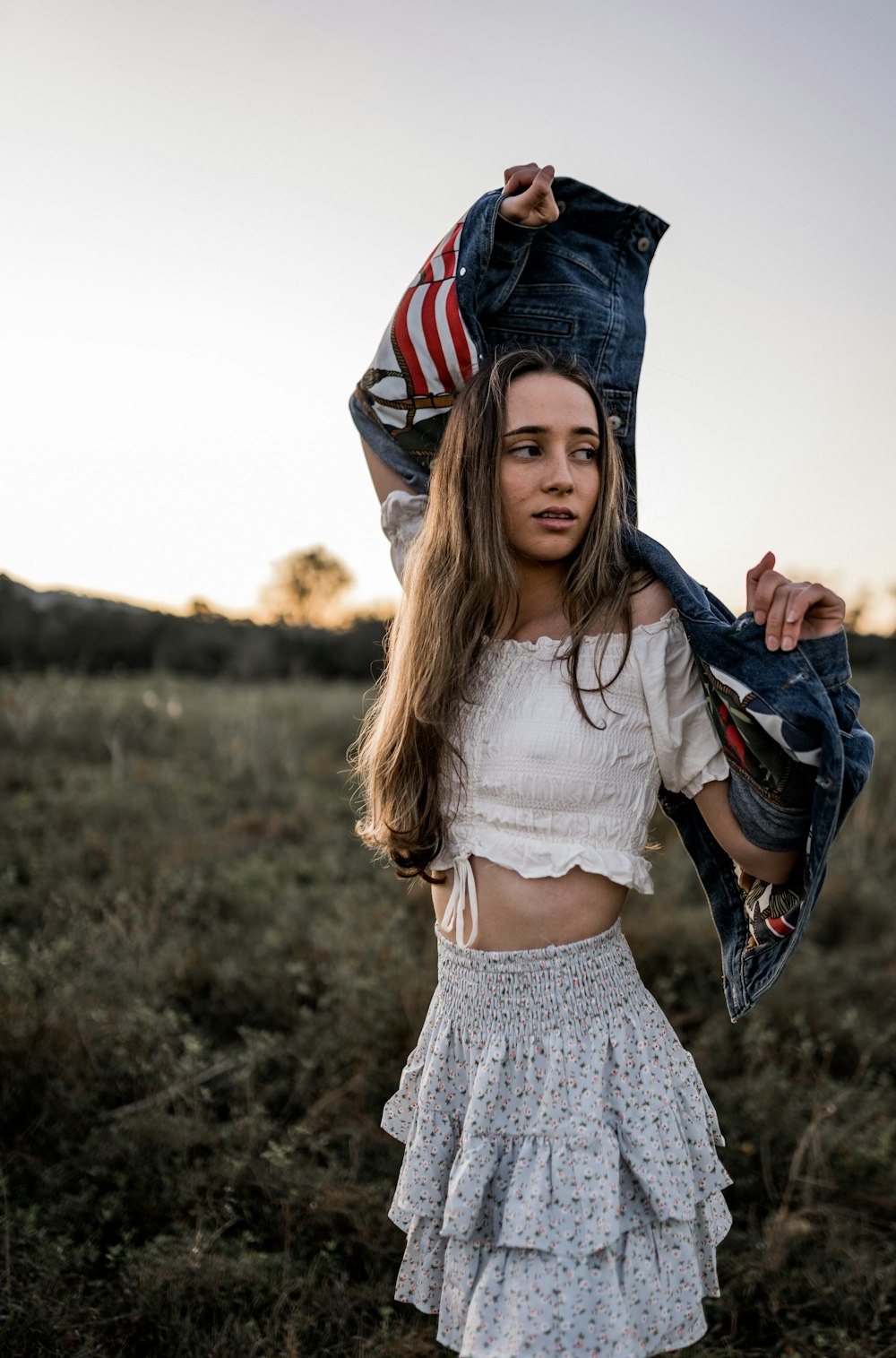 a girl in a white top and a blue jean jacket