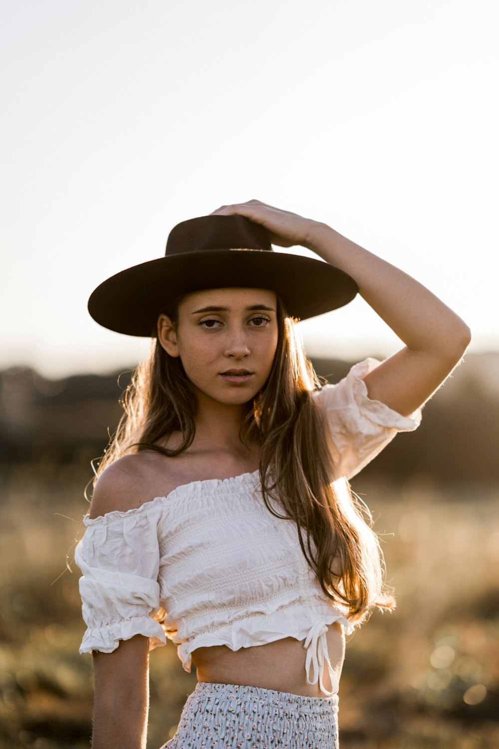 a woman in a hat poses for a picture