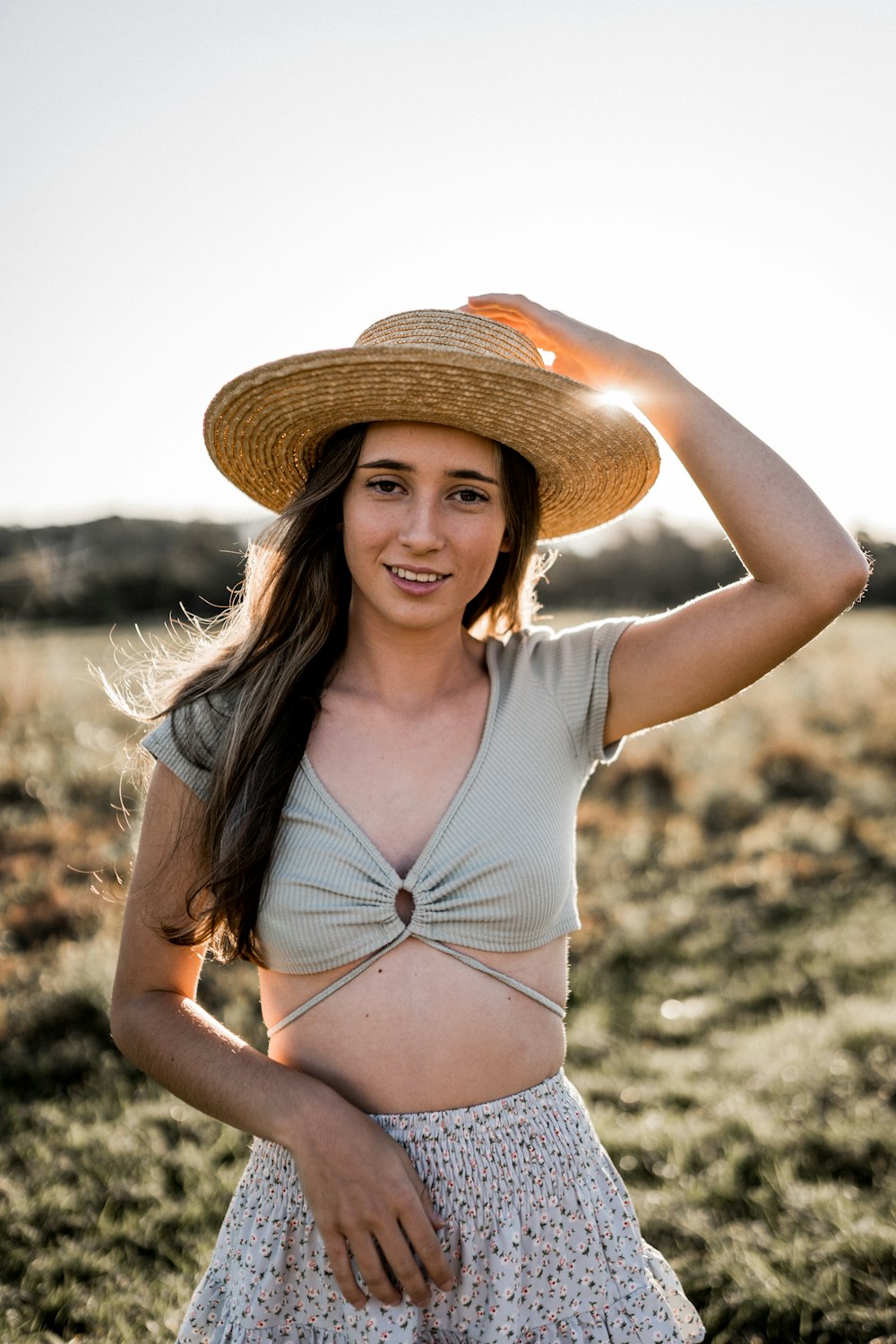 a woman wearing a straw hat in a field