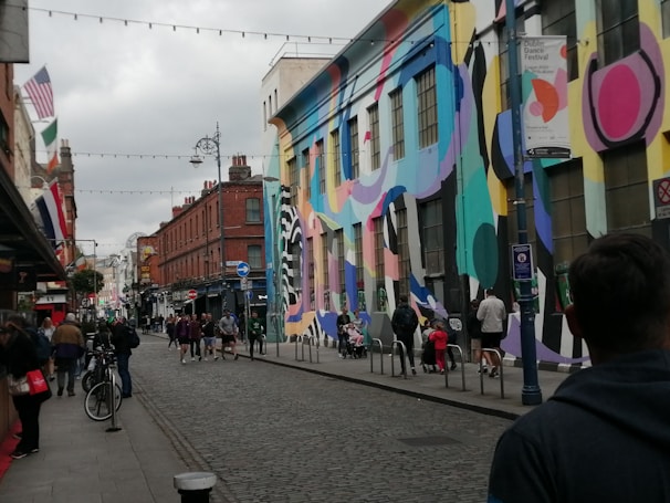 A lively street scene in Peterborough with diverse people engaging in art and community activities.