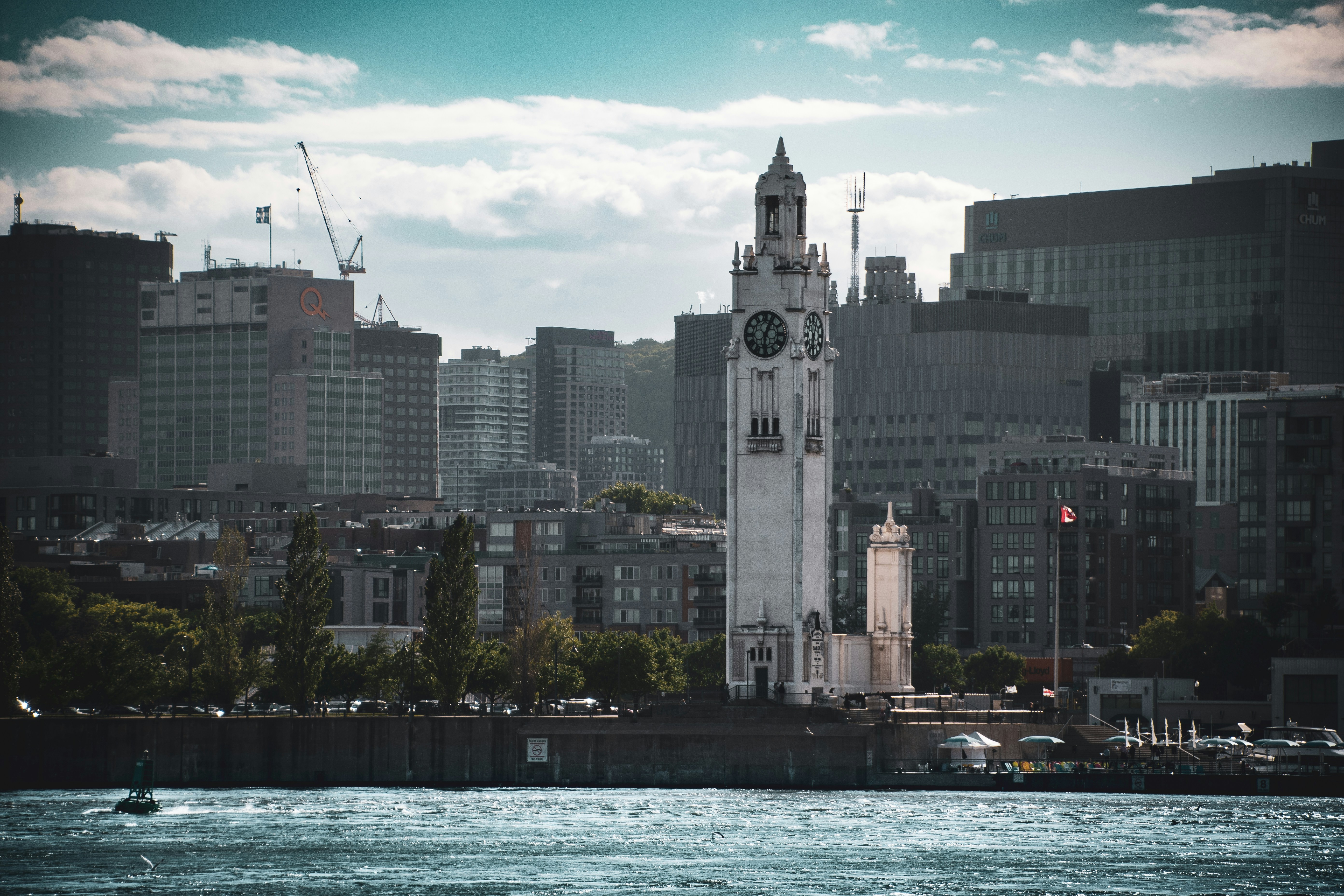 A large white clock tower towering over a city photo – Free Qc Image on  Unsplash