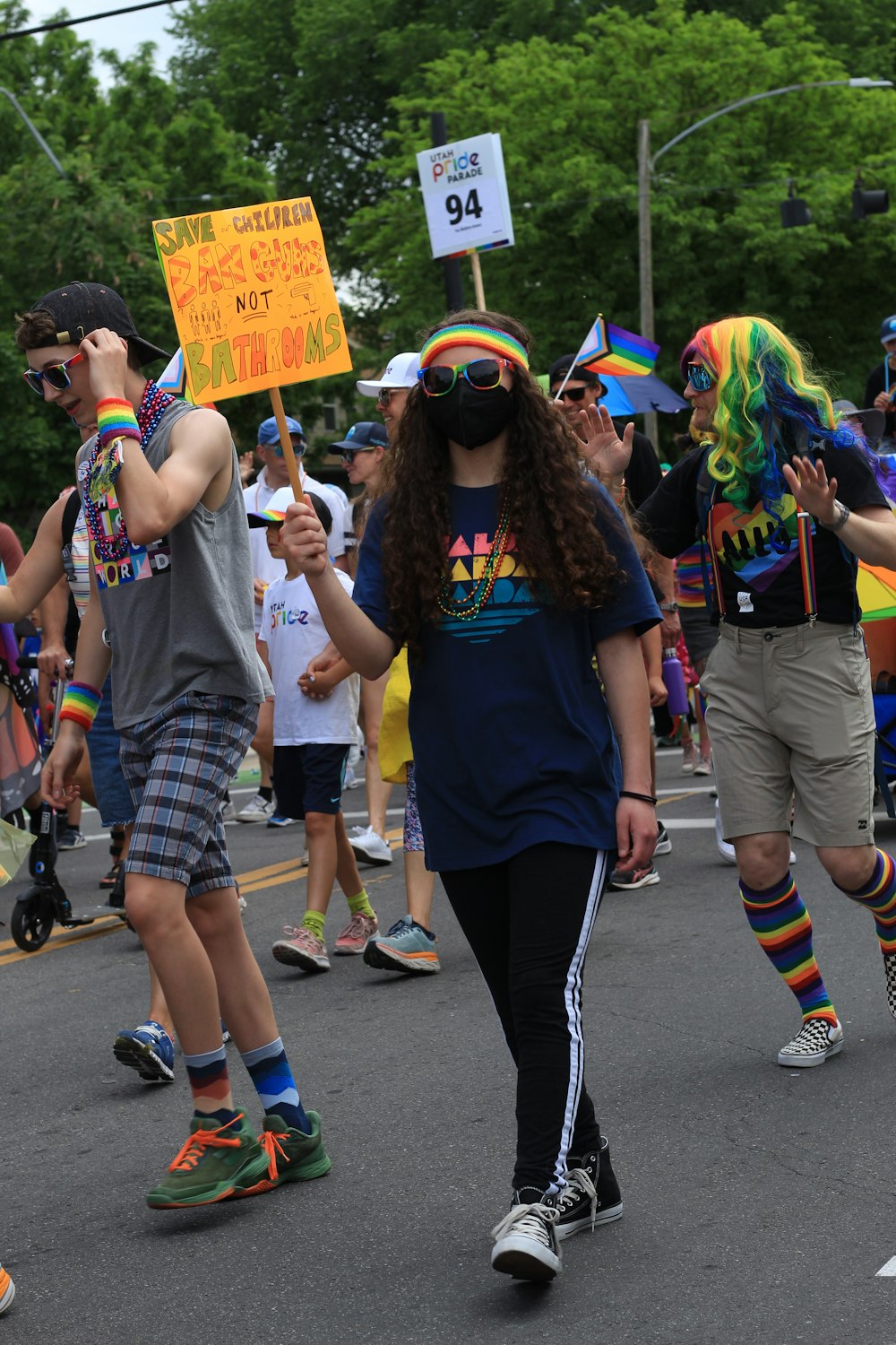 a group of people walking down a street holding signs