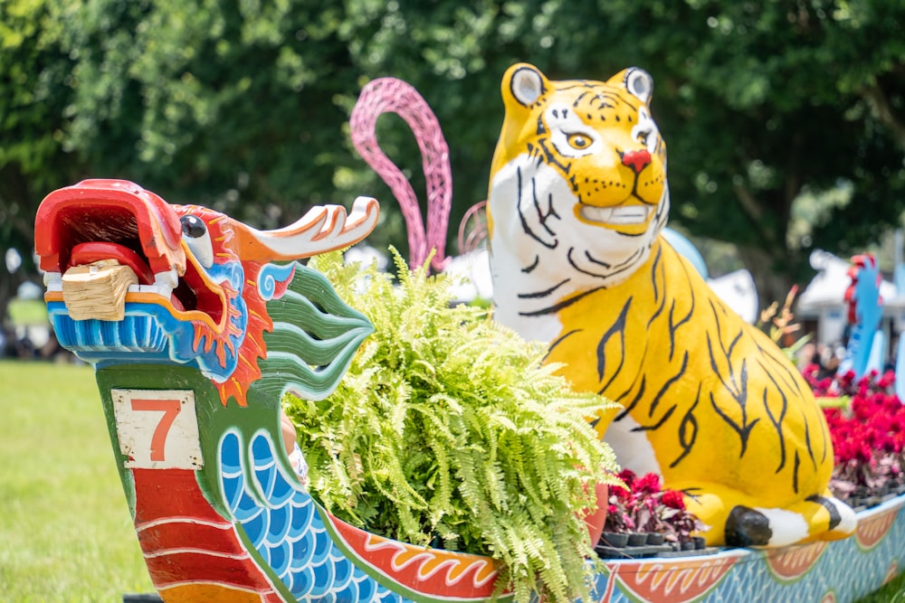 a colorfully painted dragon and tiger planter in a park