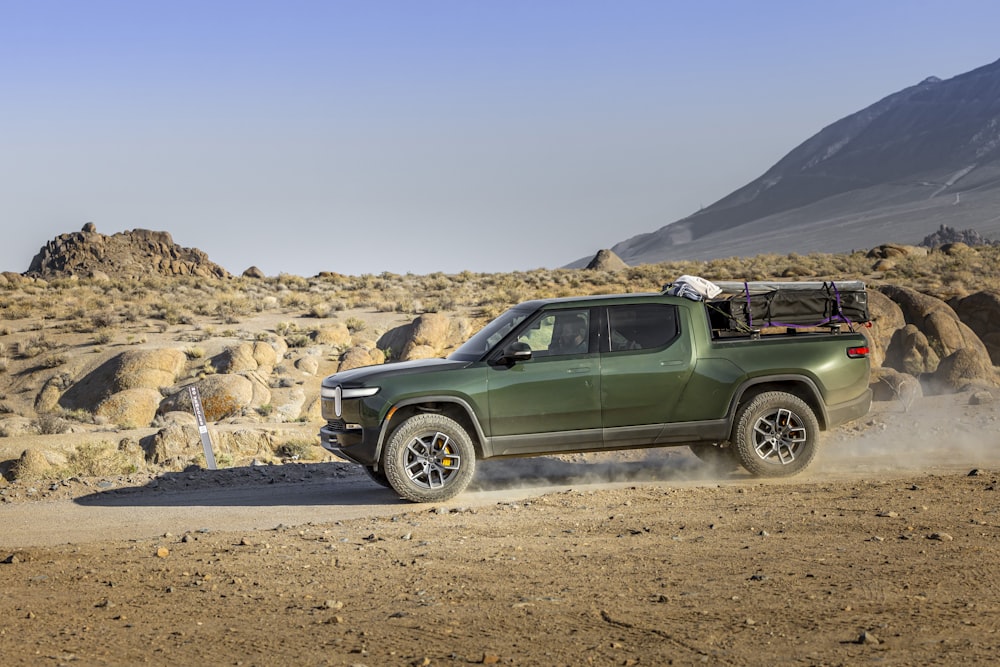 a green jeep driving on a dirt road