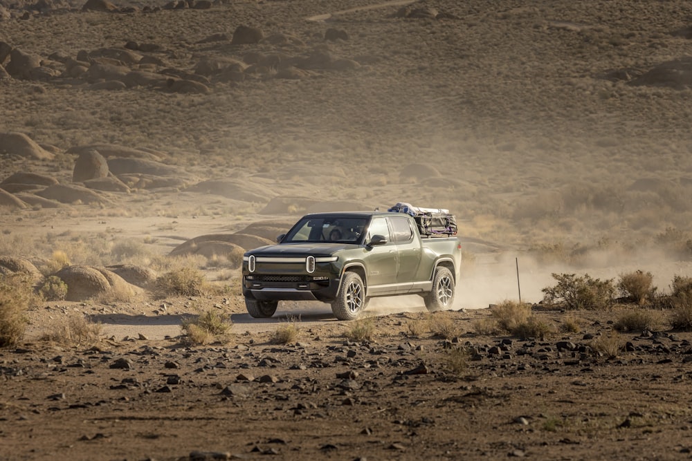 a truck driving down a dirt road in the desert