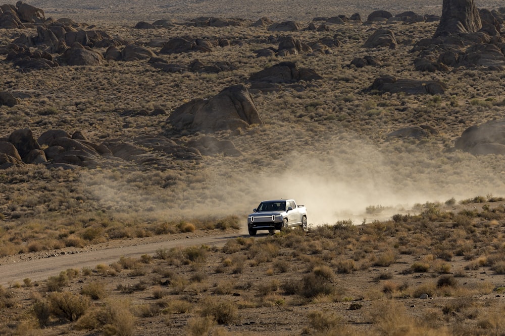 Un camión conduciendo por un camino de tierra en el desierto