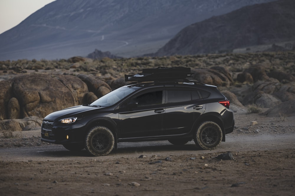 a black suv parked in the middle of a desert