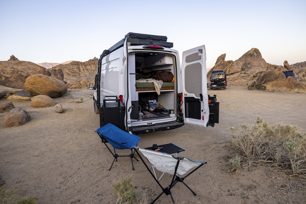 a camper van with its doors open in the desert