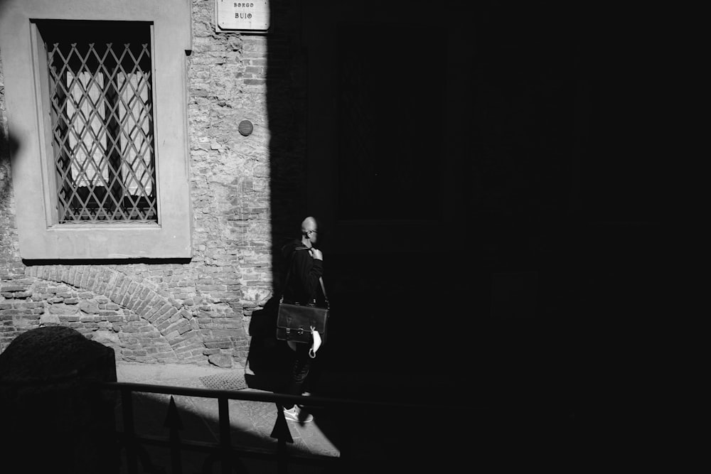 Un hombre caminando por una calle al lado de un edificio