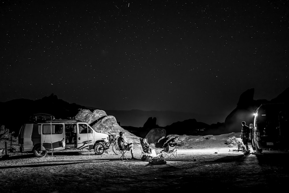 a black and white photo of a camp site at night