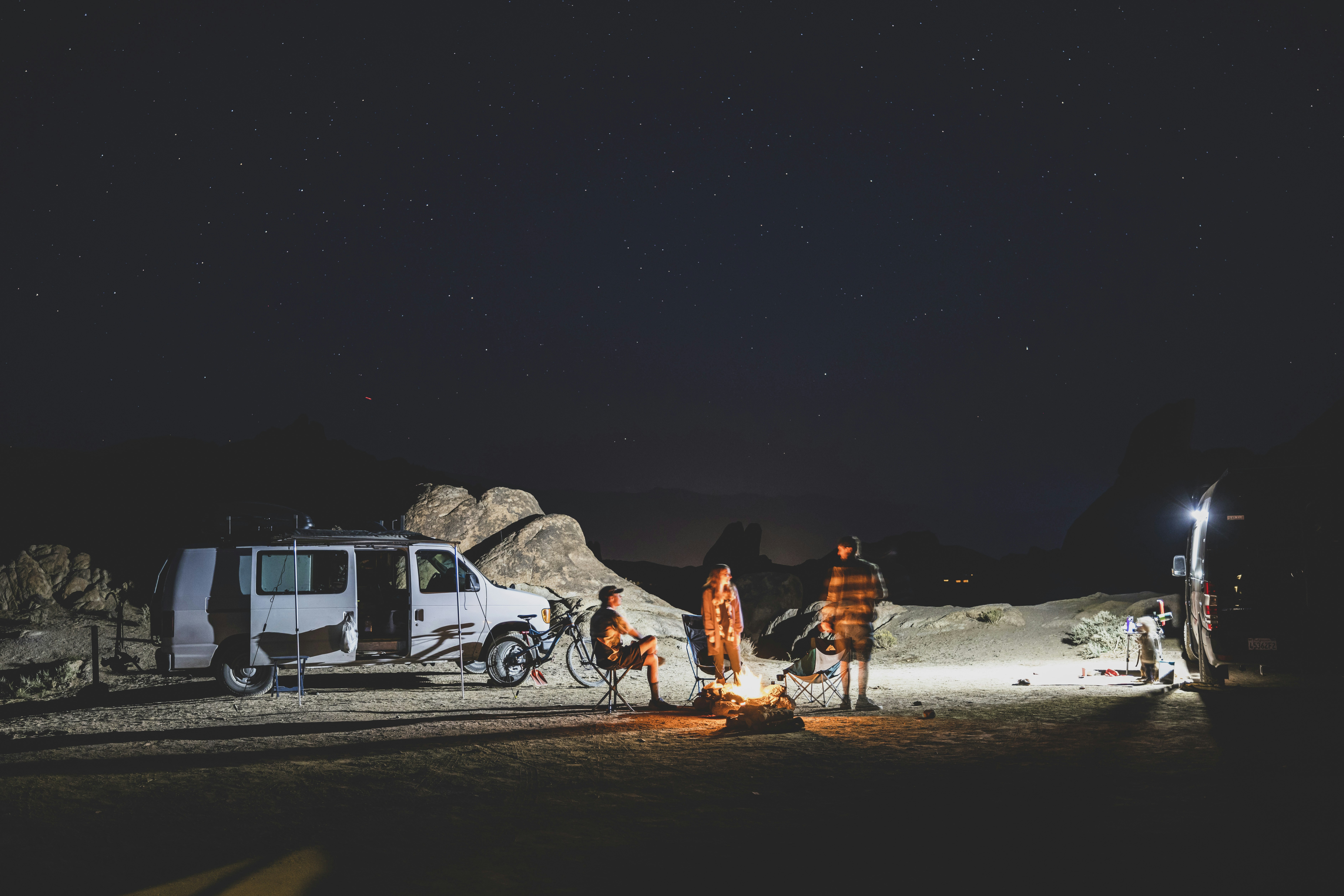 A group of people standing around a campfire photo Free Alabama hills Image on Unsplash