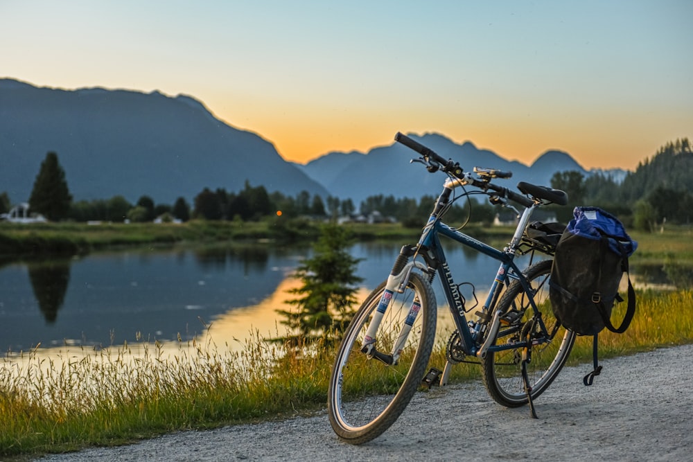 a bicycle parked on the side of a road next to a lake