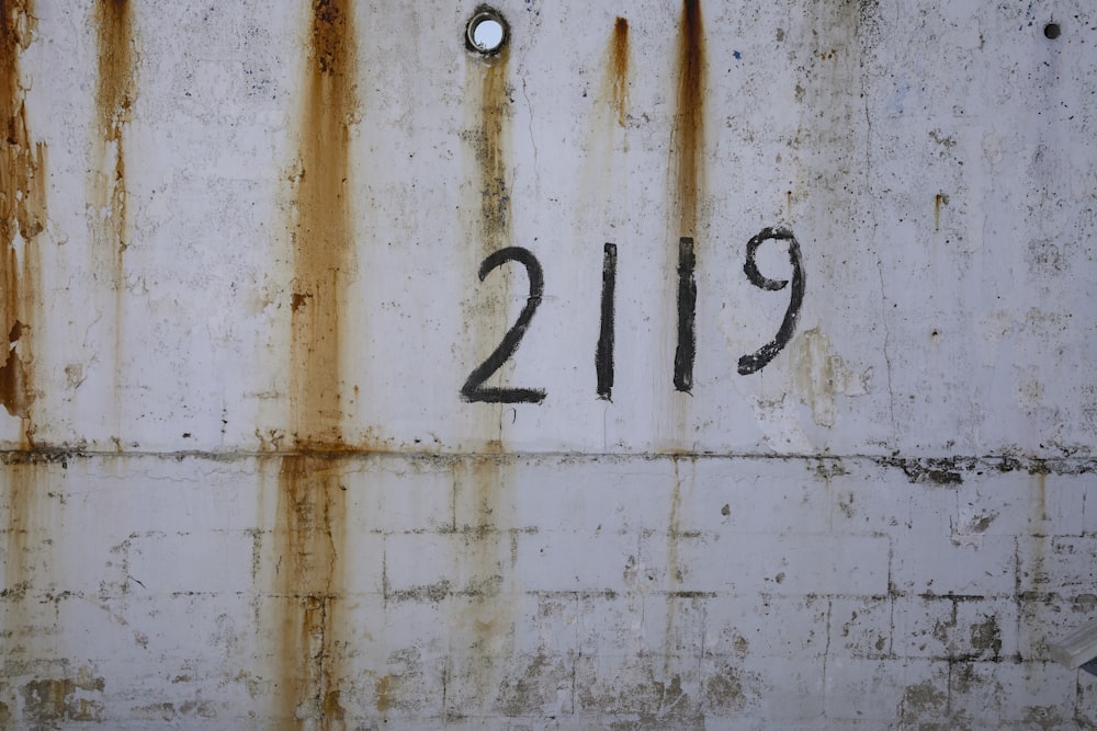 a rusted metal wall with the number 2139 painted on it