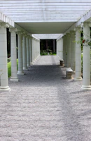 a walkway lined with white columns and benches