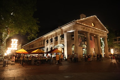 a crowd of people standing outside of a building at night