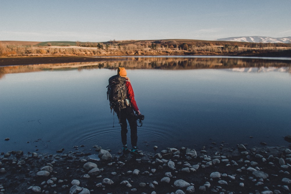 a person with a backpack is standing in the water