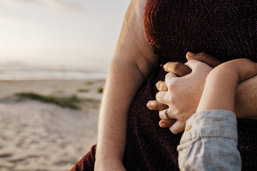 a close up of a person holding a child's hand