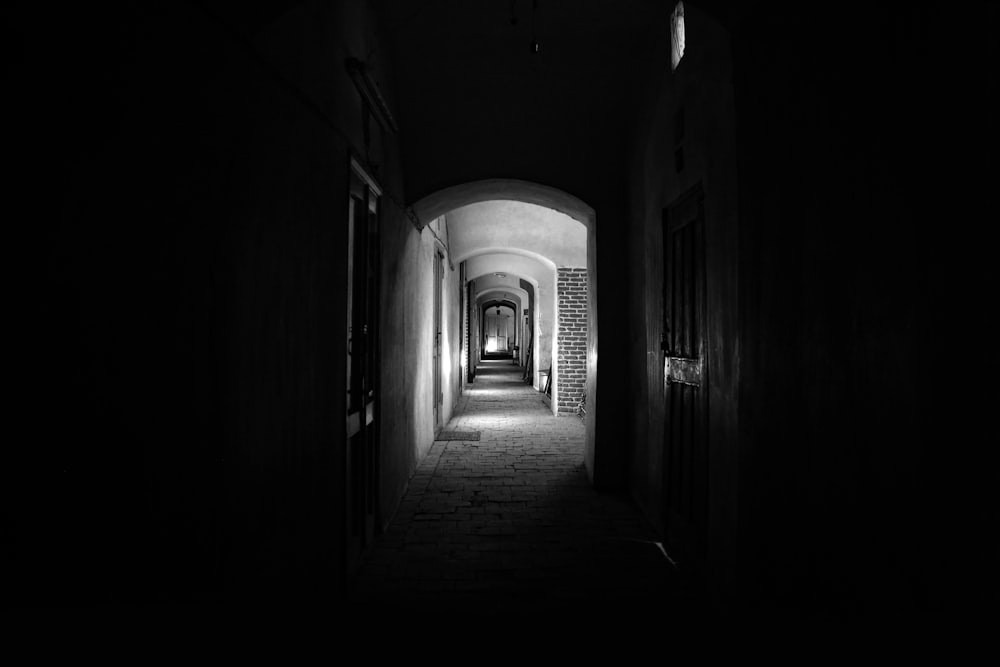 a dark hallway with a light at the end